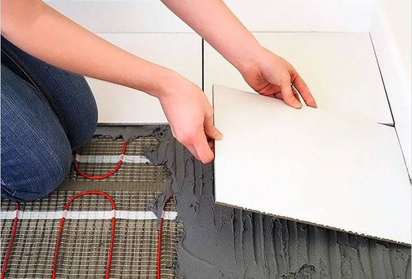 Šildomų grindų klojimas karščiui atspariu klijų mišiniu