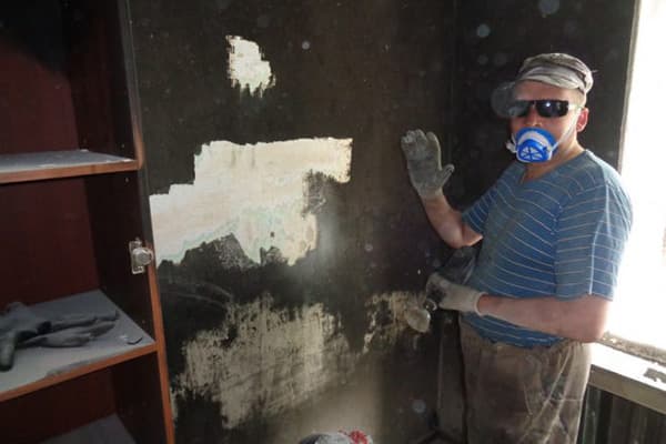 Vyras po gaisro valo suodžius nuo sienos