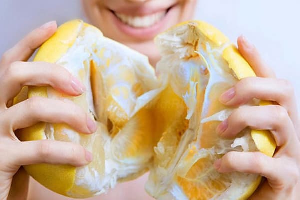 Meisje met een rijpe pompelmoes