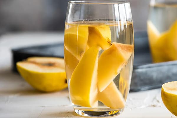 Morceaux de coings dans un verre d'eau