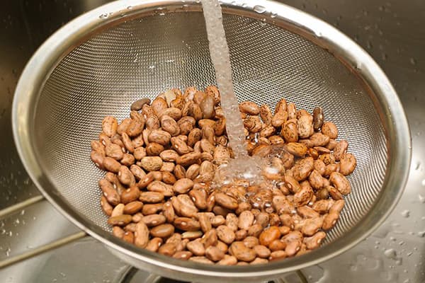 Pupelių plovimas po tekančiu vandeniu