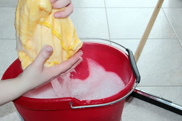 Moteris prieš skalbdama išgręžia skudurą
