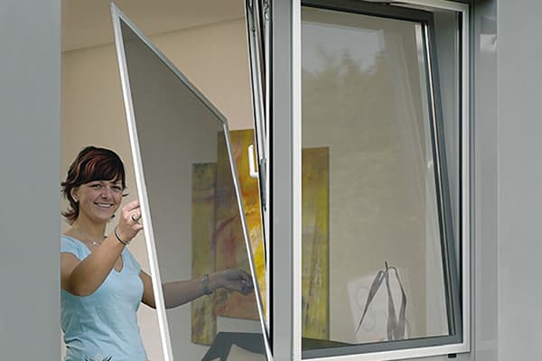 Moteris išima ekraną iš lango