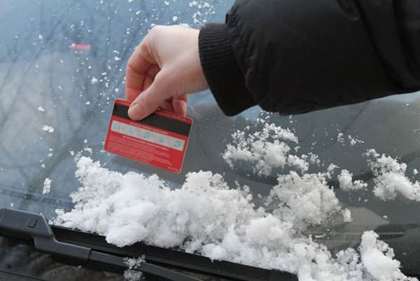 Sniego valymas nuo automobilio naudojant plastikinę kortelę