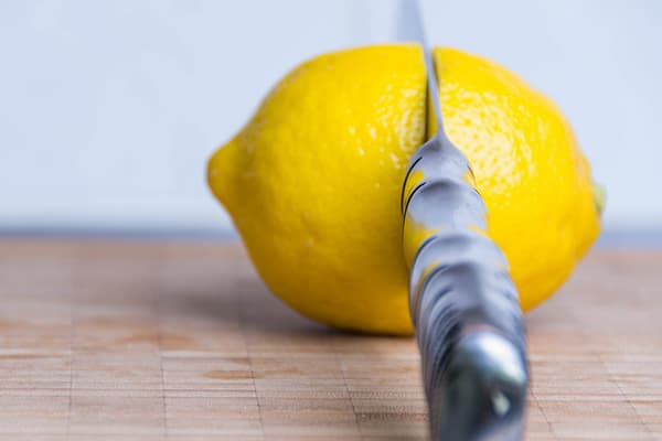 Peilis ir citrina ant pjaustymo lentos