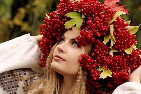 Mergina uogų ir viburnum lapų vainiku