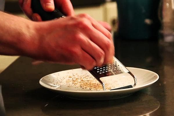 Vyras trina muskato riešutą ant trintuvės