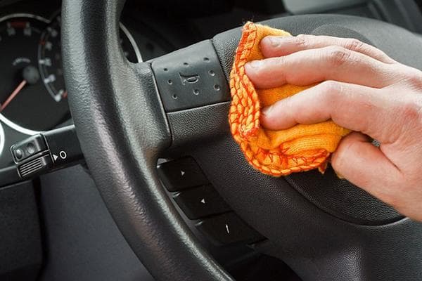 Vyras skudurėliu nuvalo automobilio vairą