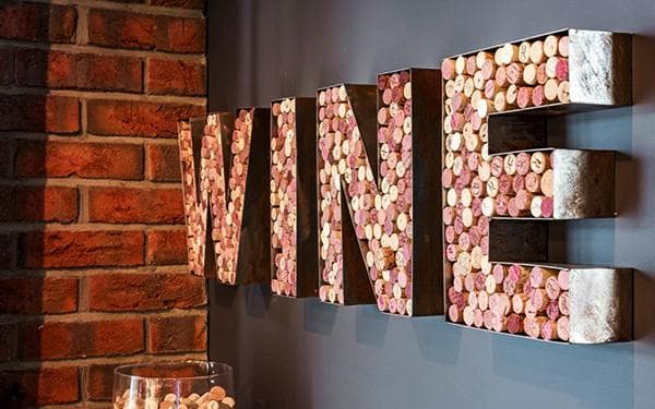 Lofto dekoras žodžio WINE forma, pagamintas iš vyno kamštelių
