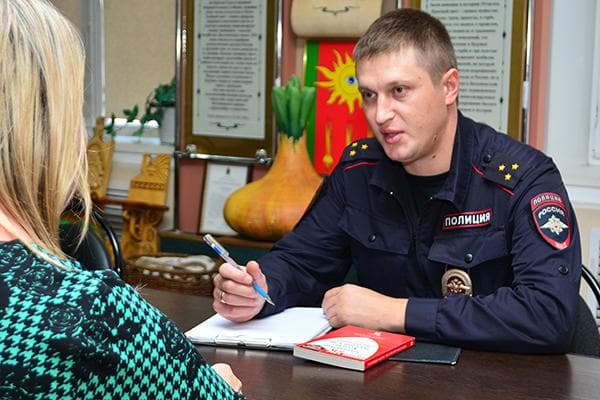 Policijos pareigūnas apklausia moterį