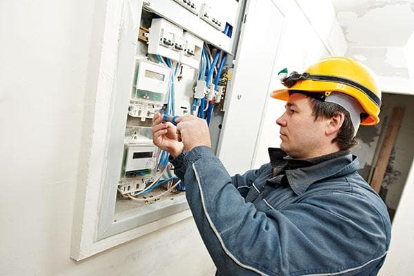 Specialistas paima elektros skaitiklį patikrinti
