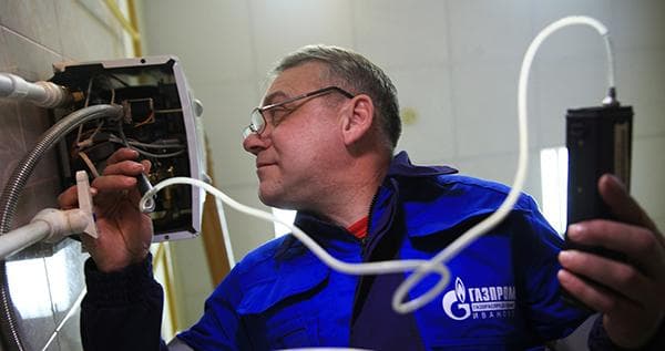Dujų serviso specialistas tikrina dujinį vandens šildytuvą