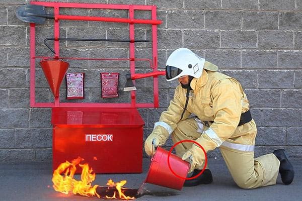 Ugniagesys užgesina liepsną vandeniu iš kibiro