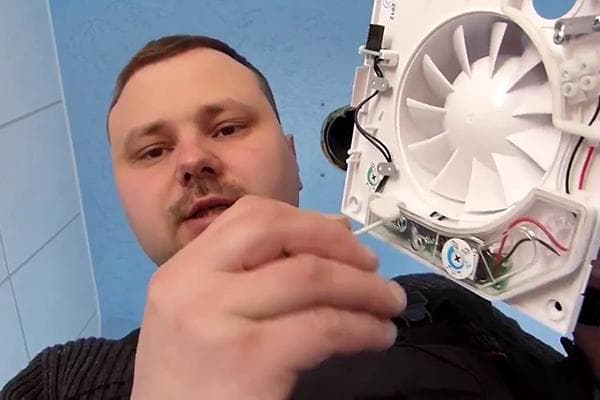 Vyras remontuoja išmetimo ventiliatorių